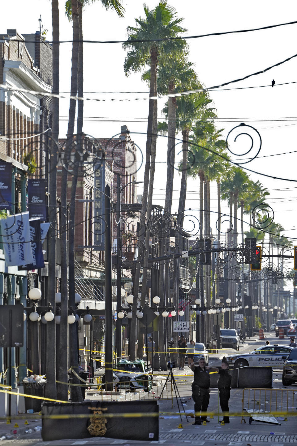 Tampa police officers stand in the street in the Ybor City section of Tampa, Fla., after a shooting early Sunday, Oct. 29, 2023. A fight between two groups turned deadly in a shooting during Halloween festivities. (AP Photo/Chris O'Meara)