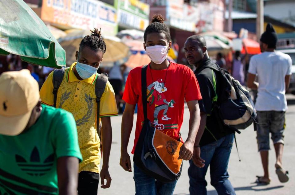 A couple of youths wearing masks to protect themselves from the spread of the new coronavirus walk in the streets of Port-au-Prince, Haiti, Monday, March 23, 2020. The vast majority of people recover from the COVID-19 disease.