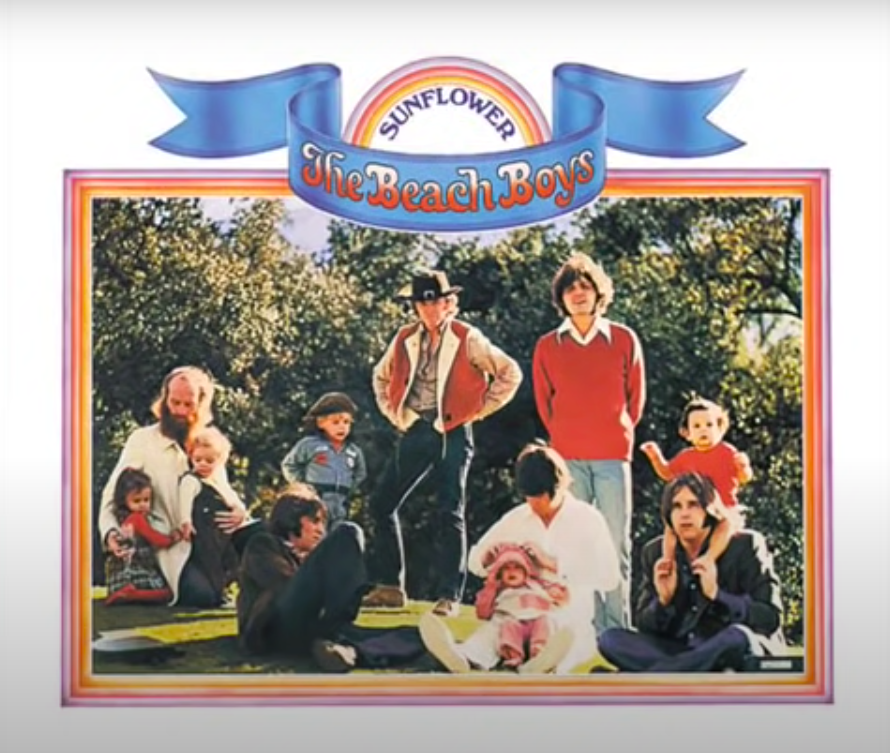 The cover art, which consists of a family of people sitting outside on grass together