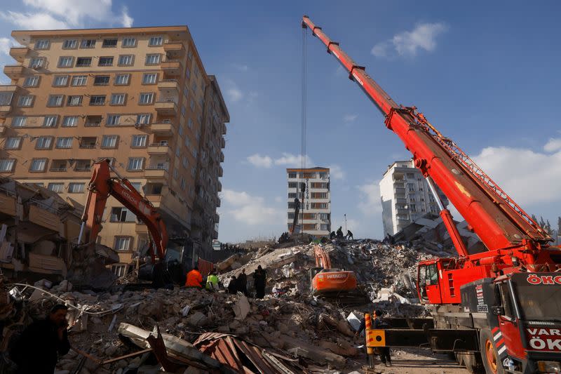 Cranes remove debris from demolished buildings following the deadly earthquake in Maras