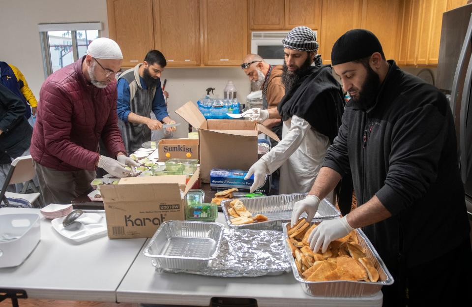 Volunteers prepare food for an evening meal during Ramadan at the  Masjid Al-Emaan mosque in Stockton on Tuesday, Apr. 18, 2023.