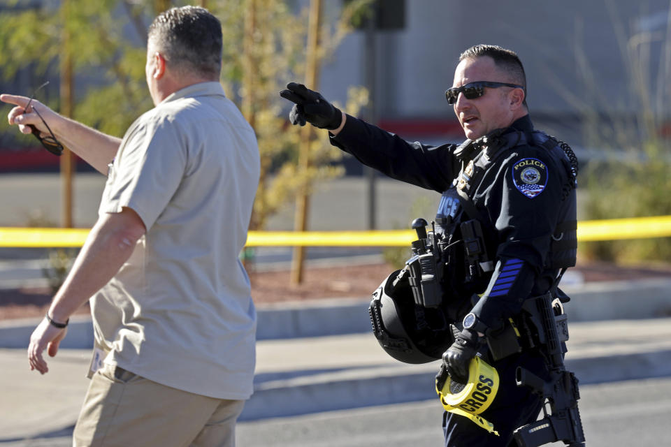 A police officer gives directions around crime scene tape after a shooting on the University of Nevada, Las Vegas, campus in Las Vegas Wednesday, Dec. 6, 2023. (K.M. Cannon/Las Vegas Review-Journal via AP)