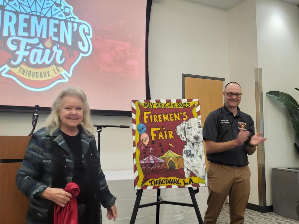 Joan Rogers unveils her daughter Michelle Eroche's artwork for this year's Thibodaux Firemen's Fair Poster. She is joined Saturday by fair Chairman Walton Guidry. Eroche was unable to attend.