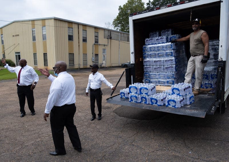 Members of Progressive Morningstar Baptist Church direct people to get bottled water following a Sunday morning service in Jackson, Mississippi, on September 4, 2022. - The church has reached out to various churches from across the state of Mississippi to help supply the church with bottled water to pass out to its congregation and the community as residents in Jackson continue to endure water setbacks. The city of Jackson, where 80 percent of the population is Black and poverty is rife, has experienced water crises for years. But this one is particularly severe, with many residents lacking clean running water for nearly a week. 