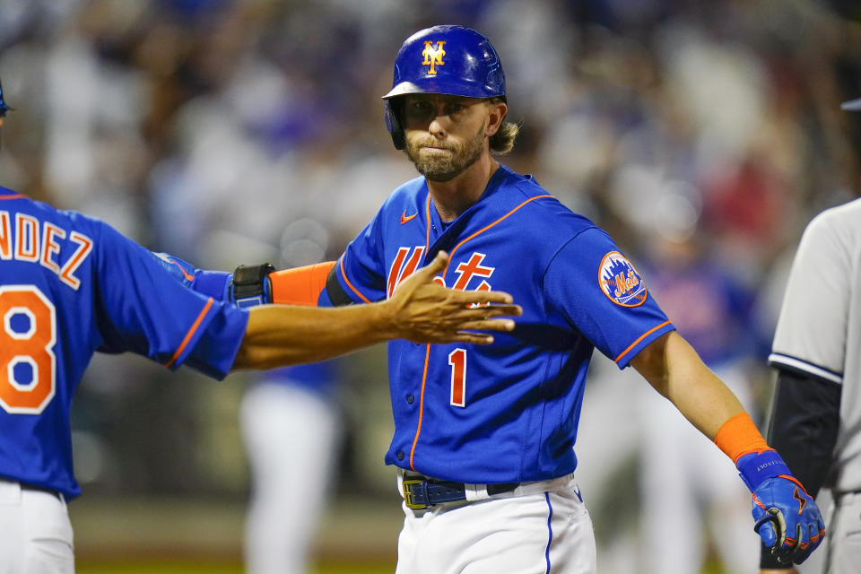 New York Mets' Jeff McNeil (1) celebrates with first base coach Rafael Fernandez after hitting an RBI single during the eighth inning of a baseball game against the New York Yankees Tuesday, July 26, 2022, in New York. The Mets won 6-3. (AP Photo/Frank Franklin II)