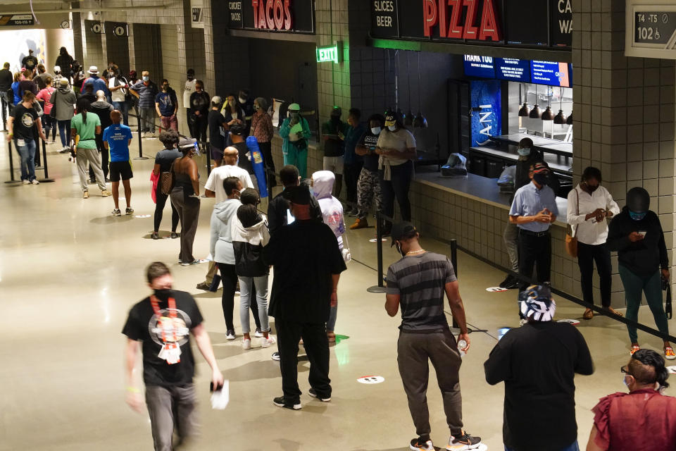 People wait in line to vote early at the State Farm Arena on Monday, Oct. 12, 2020, in Atlanta. (AP Photo/Brynn Anderson)