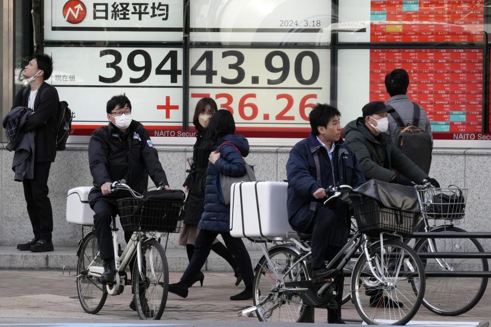 People stop in front of an electronic stock board showing Japan's Nikkei 225 index at a securities firm Monday, March 18, 2024, in Tokyo. Asian stocks advanced Monday ahead of policy decisions this week by Japan’s central bank and the Federal Reserve. (AP Photo/Eugene Hoshiko)