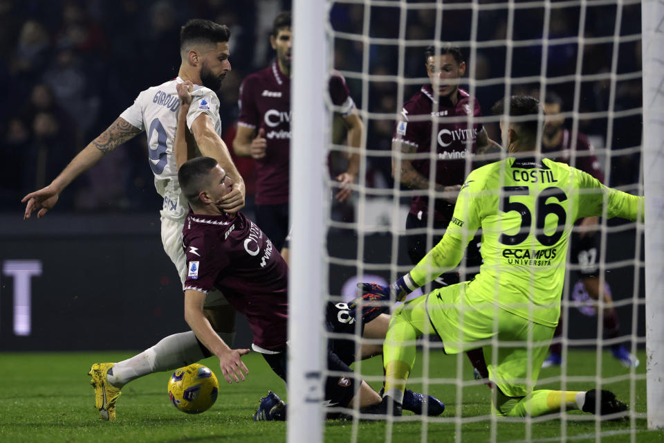 Olivier Giroud (izquierda), del Milan, disputa un balón con Lorenzo Pirola, del Salernitana, en el duelo del viernes 23 de diciembre de 2023 (Alessandro Garofalo/LaPresse via AP)