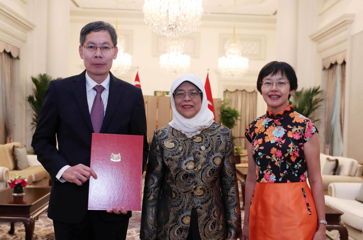 Former Transport Minister Lui Tuck Yew (left) receives the letter of credence as Singapore’s Ambassador-designate to the People’s Republic of China from President Halimah Yacob. On the right is his wife Soo Fen. (PHOTO: Ministry of Communications and Information)