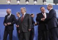 U.S. Secretary of State Mike Pompeo, second right, speaks with Russian President Vladimir Putin, right, after a group photo at a conference on Libya at the chancellery in Berlin, Germany, Sunday, Jan. 19, 2020. German Chancellor Angela Merkel hosts the one-day conference of world powers on Sunday seeking to curb foreign military interference, solidify a cease-fire and help relaunch a political process to stop the chaos in the North African nation. (AP Photo/Michael Sohn)