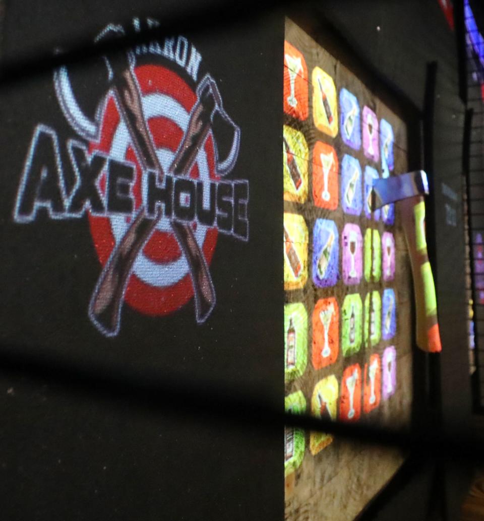 A hatchet sticks in a target that is projected on the board at the Akron Axe House in downtown Akron on Friday.