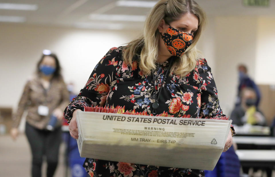 An election worker carries mail-in ballots to be processed by election workers in Salt Lake City on Oct. 29, 2020.  (Photo: GEORGE FREY via Getty Images)