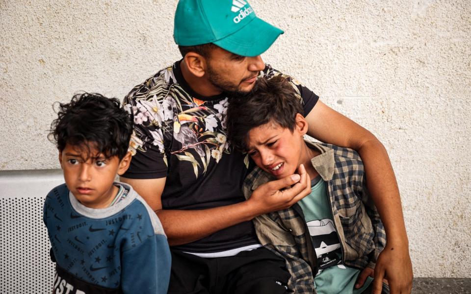 A child mourns the death of people killed in overnight Israeli bombardment, in the front of the morgue of a hospital in Rafah