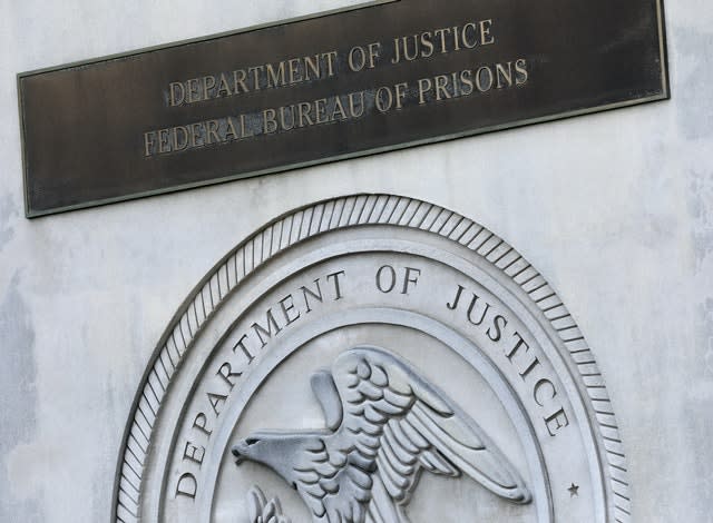 A sign for the Department of Justice Federal Bureau of Prisons is displayed at the Metropolitan Detention Centre (Mark Lennihan/AP)