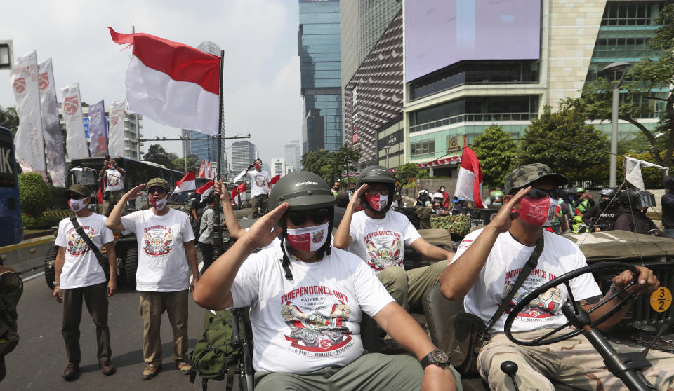 Participants salute during the 75th Independence Day commemoration in Jakarta, Indonesia, Monday, Aug. 17, 2020. Indonesia gained its independence in 1945 from the Dutch colonial rule. (AP Photo/Achmad Ibrahim)