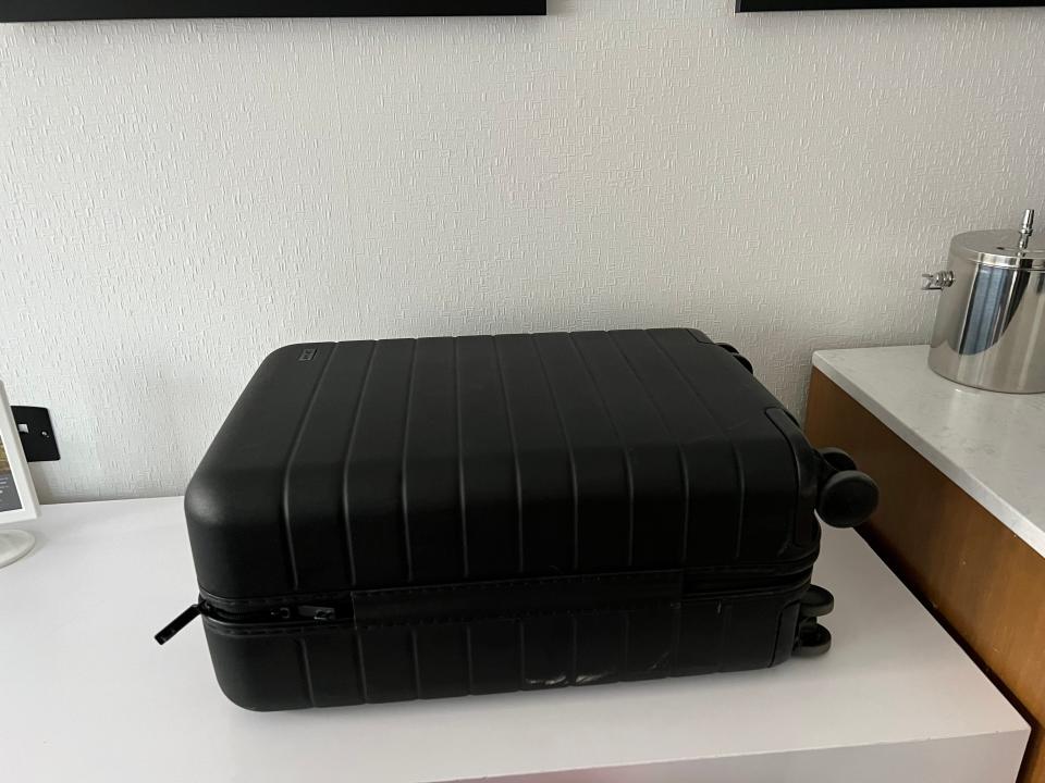 Black suitcase on white counter in hotel room