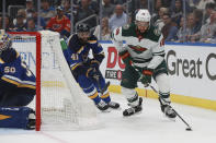 Minnesota Wild's Jordan Greenway (18) moves the puck as St. Louis Blues' Robert Bortuzzo (41) defends behind the Blues' goal during the first period in Game 6 of an NHL hockey Stanley Cup first-round playoff series Thursday, May 12, 2022, in St. Louis. (AP Photo/Michael Thomas)