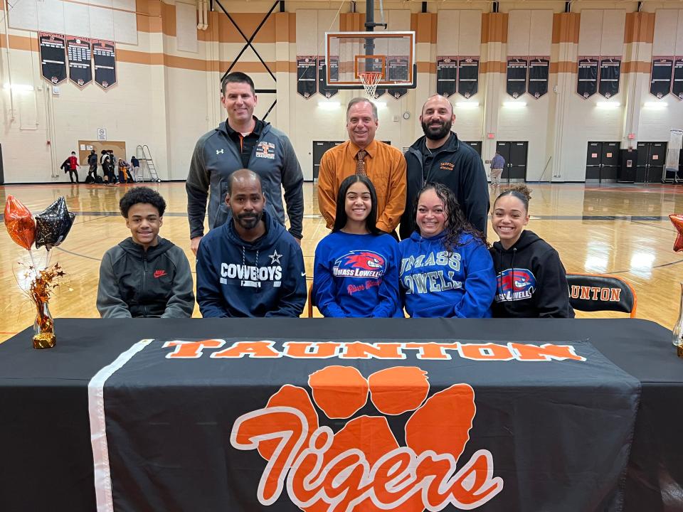 Nia Mainer Smith (center, front row) committed to UMass Lowell in an NLI signing ceremony Thursday. Front row, from left to right: Johnnie Mainer-Smith, Jamal Mainer-Smith, Nia Mainer-Smith, Milagros Mainer-Smith, Tatyana Mainer-Smith. Back row left to right: former Taunton track coach Jeff Moore, Athletic Director Mark Ottavianelli and former track and boys cross country coach Jason Torres.