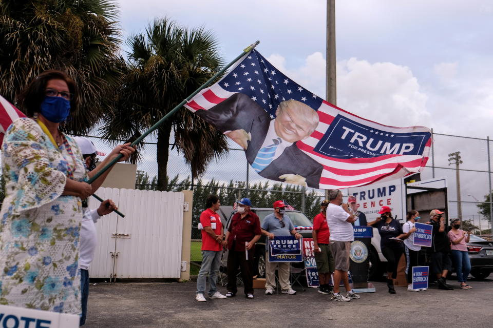 Trump supporters shout and wave flags outside the John F. Kennedy Library polling station in Hialeah, Fla.