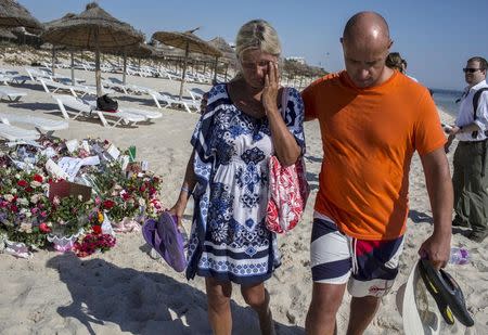 A tourist reacts after paying tribute at a makeshift memorial at the beachside of the Imperial Marhaba resort, which was attacked by a gunman in Sousse, Tunisia, June 29, 2015. REUTERS/Zohra Bensemra