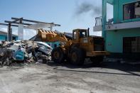 A worker in a bulldozer cleans debris from the parking lot of a private shopping center after Hurricane Dorian hit the Abaco Islands in Marsh Harbour