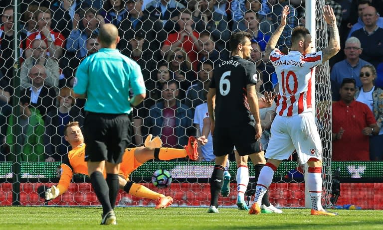 Liverpool's goalkeeper Simon Mignolet (L) dives but fails to save a shot from Stoke City's Jonathan Walters during their English Premier League match, at the Bet365 Stadium in Stoke-on-Trent, on April 8, 2017