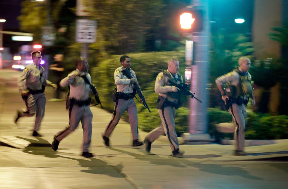 FILE - Police run toward the scene of a shooting near the Mandalay Bay resort and casino on the Las Vegas Strip in Las Vegas on Oct. 1, 2017. The Supreme Court has struck down a Trump-era ban on bump stocks, a gun accessory that allows semiautomatic weapons to fire rapidly like machine guns. They were used in the deadliest mass shooting in modern U.S. history. The high court Friday found the Trump administration did not follow federal law when it reversed course and banned bump stocks after a gunman in Las Vegas attacked a country music festival with assault rifles in 2017. (AP Photo/John Locher, File)