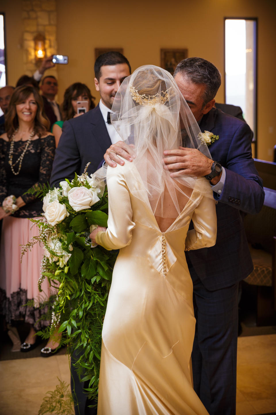 Pilar at her wedding ceremony at St. John Maron Church in Orange, California. In this photo, you can see the back of the dress, which was changed to a deep V before her mother Marta's wedding in 1983.&nbsp; (Photo: <a href="http://www.memoriesbymichael.com/" target="_blank">Michael Jonathan Studios</a>)