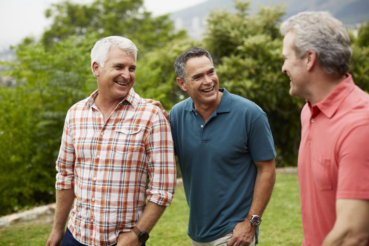 Happy mature male friends spending leisure time in park habits