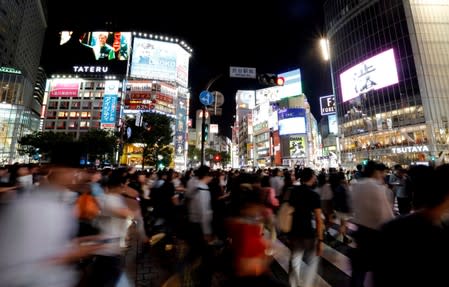 Pedestrians walk at a scramble crossing at Shibuya shopping district in Tokyo