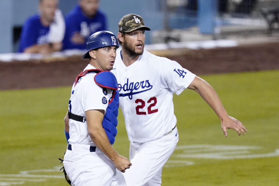 Los Angeles Dodgers catcher Austin Barnes, left, watches his throw to first along with starting pitcher Clayton Kershaw to get Miami Marlins' Adam Duvall out during the fifth inning of a baseball game Friday, May 14, 2021, in Los Angeles. (AP Photo/Mark J. Terrill)