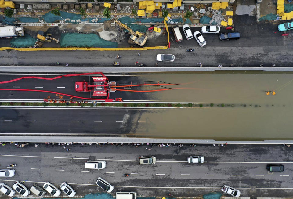 In this aerial photo released by Xinhua News Agency, firefighters pump rainwater from a road underpass in Zhengzhou in central China's Henan province on Wednesday, July 21, 2021. China's military has blasted a dam to release floodwaters threatening one of its most heavily populated provinces, as the death toll in widespread flooding rose to more than two dozens. (Ma Xiaoran/Xinhua via AP)