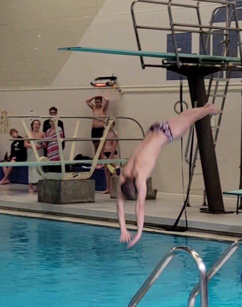 Bloomington North's Max Miller hits the water during the diving competition at the Columbus North Sectional in 2022.