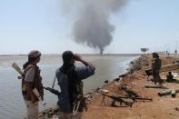 Smoke billows on the horizon as supporters of exiled Yemeni President Abedrabbo Mansour Hadi block a road in al-Mansura, east of Aden, on April 29, 2015