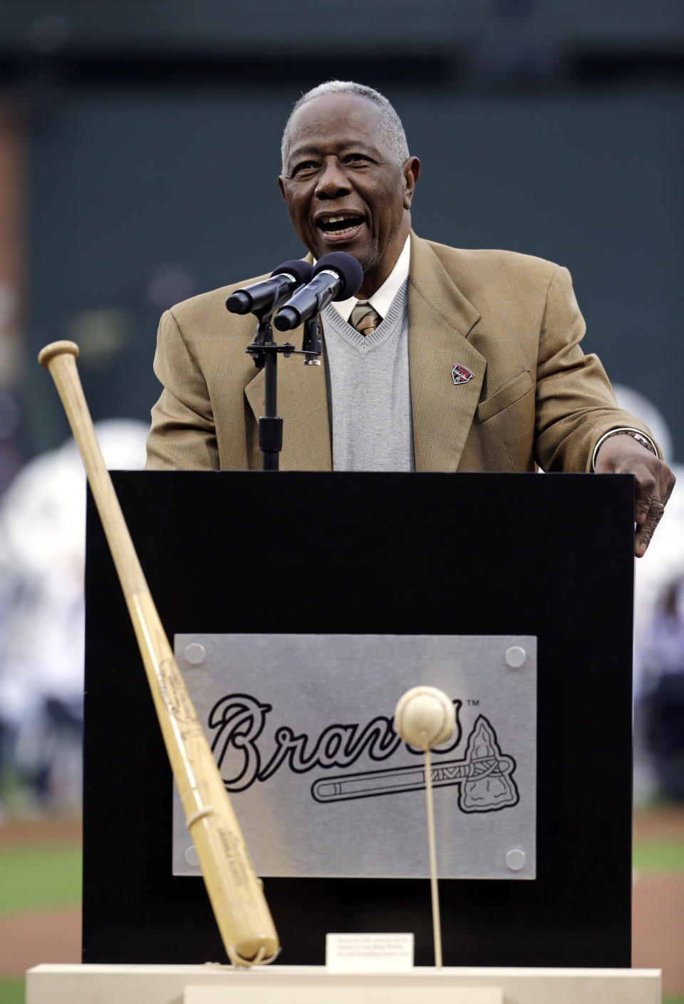 Hank Aaron speaks during a ceremony celebrating the 40th anniversary of his 715th home run as the actual bat and ball from the hit stand on display before the start of a baseball game between the Atlanta Braves and the New York Mets, Tuesday, April 8, 2014, in Atlanta. (AP Photo/David Goldman)