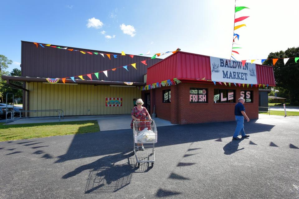 Shoppers leave the newly opened Baldwin Market during its soft opening on Sept. 20, 2019. The 10,000 square foot building was too small for big grocery retailers so the town, which already owned the building, decided to staff and stock it for the convenience of residents.