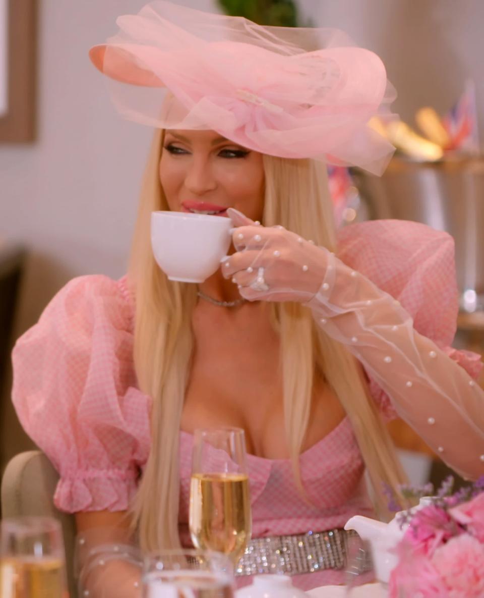 <p>For tea, Quinn tacked some kitschy accessories onto her pouf-sleeved dress, including pearl-finished sheer gloves, a tulle fascinator, a pearl ring, and a rhinestone belt.</p>