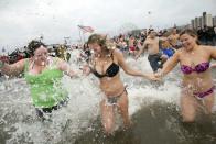 People enter the water while taking part in the Coney Island Polar Bear Club's annual New Year's Day Polar Bear Swim in New York's Coney Island January 1, 2013. The Coney Island Polar Bear Club is the oldest winter bathing organization in the U.S. and every New Years Day holds the winter plunge which attracts thousands of participants.