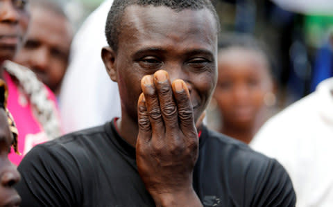 A man reacts outside the entrance of Connaught Hospital in Freetown - Credit: Reuters