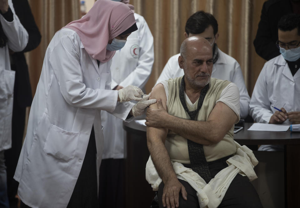 Former Palestinian Health Minister Jawad al-Tibi receives a shot of the COVID-19 Russian-made Sputnik V vaccine, in Gaza City, Monday, Feb. 22, 2021. (AP Photo/Khalil Hamra)