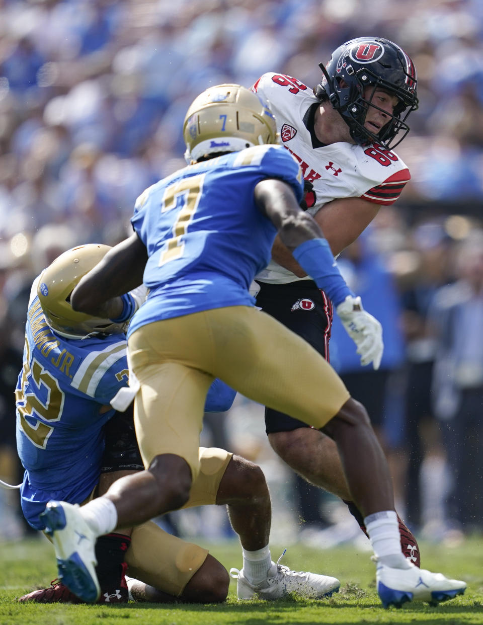 Utah tight end Dalton Kincaid (86) is tackled by UCLA defensive back William Nimmo Jr. (32) and defensive back Mo Osling III (7) during the first half of an NCAA college football game in Pasadena, Calif., Saturday, Oct. 8, 2022. (AP Photo/Ashley Landis)