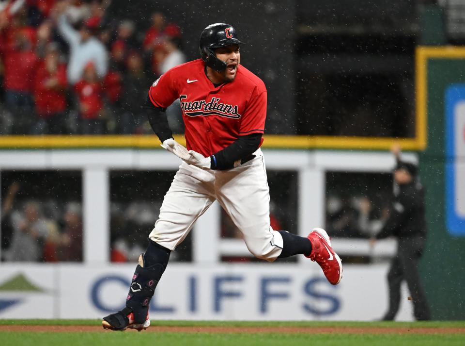 Guardians designated hitter Josh Naylor "rocks the baby" as he rounds the bases after hitting a home run in the 2023 ALDS vs. the Yankees.