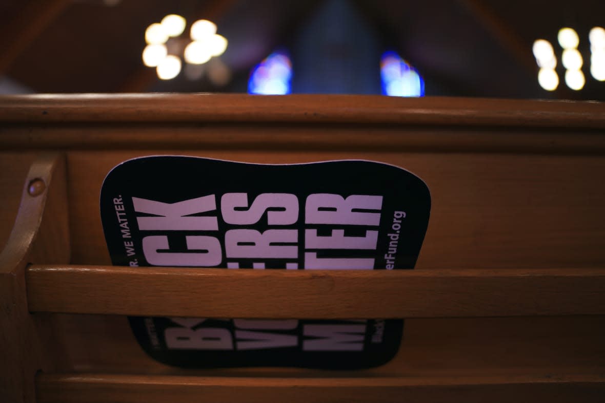 A fan reading Black Voters Matter sits in the back of a pew at Bethel AME Church on Tuesday, April 11, 2023, in Pittsburgh. More than 60 years after the church was forced to relocate, in what’s being called a step toward “restorative justice,” Bethel is poised to obtain use of a 1.5-acre parcel near its former site in an agreement with the Pittsburgh Penguins, holders of development rights to the area. (AP Photo/Jessie Wardarski)