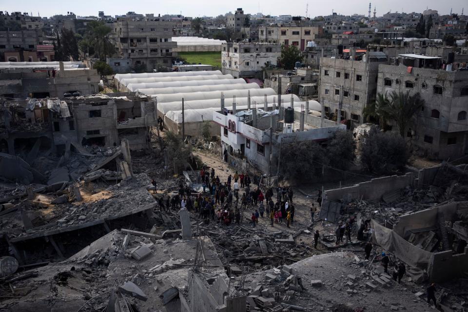 Palestinians inspect the damage to residential buildings where two Israeli hostages were reportedly held before being rescued during an operation by Israeli security forces in Rafah, southern Gaza Strip, Monday, Feb. 12, 2024. The Israeli military said early Monday that it had rescued the two hostages from captivity in the Gaza Strip. The operation, which was accompanied by airstrikes, killed dozens of Palestinians, according to local health officials. (AP Photo/Fatima Shbair)