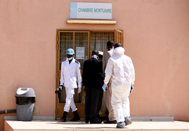 Forensic experts and medics are pictured at the door of the morgue of the Bogodogo District Hospital in Ouagadougou