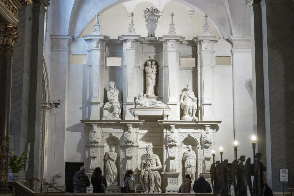 Visitors admire the tomb of Pope Julius II, with the central marble statue of Mosè, made by Italian sculptor Michelangelo Buonarroti between 1505 and 1545, inside the San Pietro in Vincoli church, in Rome, Friday, Dec. 11, 2020. Like elsewhere in Europe, museums and art galleries in Italy were closed this fall to contain the spread of COVID-19, meaning art lovers must rely on virtual tours to catch a glimpse of the treasures held by famous institutions such as the Uffizi in Florence and the Vatican Museums in Rome. However, some exquisite gems of Italy's cultural heritage remain on display in real life inside the country's churches, some of which have collections of renaissance art and iconography that would be the envy of any museum. (AP Photo/Andrew Medichini)