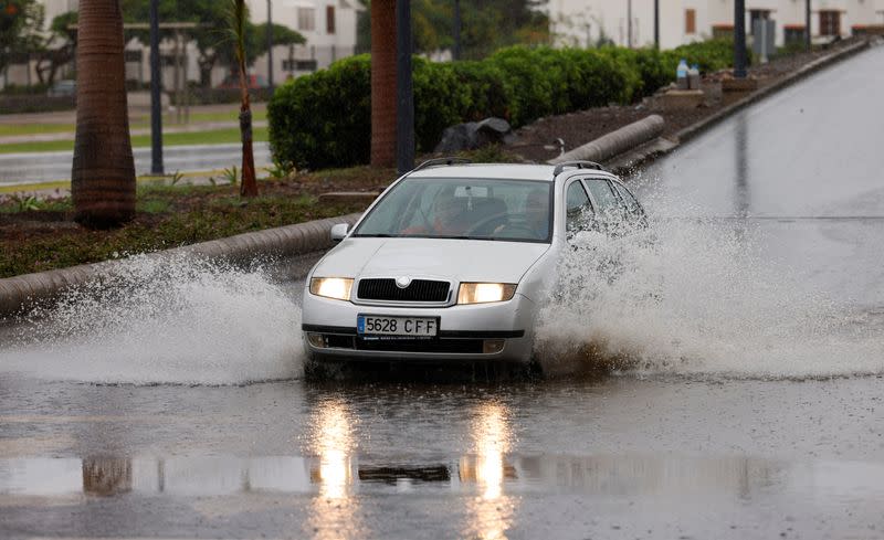 A vehicle passes through a large puddle of water caused by rain by the tropical storm Hermine