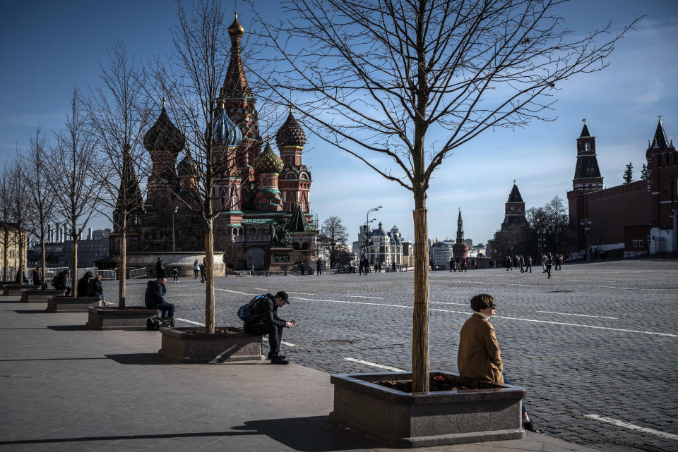 Algunas personas se sientan guardando distancia en la Plaza Roja, en Moscú, el 26 de marzo de 2020. (Sergey Ponomarev/The New York Times)