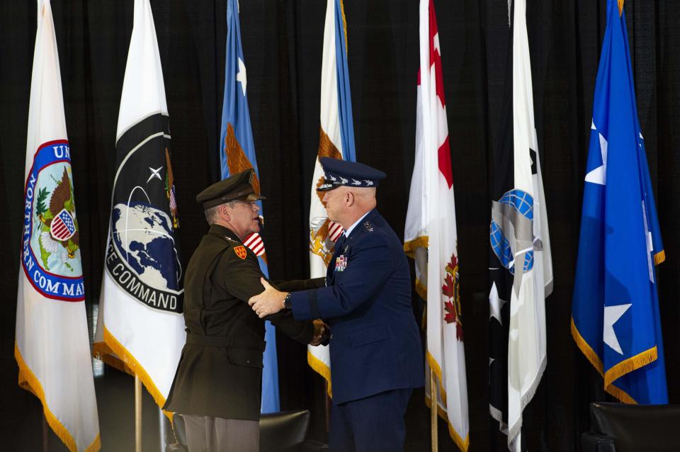 Incoming Chief of Space Operations Gen. James Dickinson, left, and outgoing Chief of Space Operations Gen. John Raymond shake hands Thursday, Aug. 20, 2020, during a change of command ceremony for the U.S. Space Command at Peterson Air Force Base in Colorado Springs, Colo.