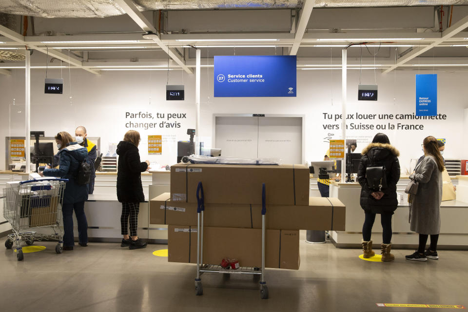 Customers wearing face masks as a precaution against the spread of coronavirus, wait at customer services in an Ikea store on its reopening day, in Geneva, Switzerland, Monday, March 1, 2021. Swiss authorities last week gave a go-ahead to what they called a “cautious” reopening despite a new, more-transmissible COVID-19 variant that first appeared in Britain that is increasingly circulating in the rich Alpine country. (Salvatore Di Nolfi/Keystone via AP)